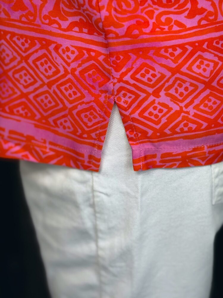 Rotes gemustertes Hemd und weiße Hose in Nahaufnahme.