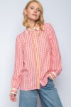 Frau trägt gemustertes Hemd und Jeans.