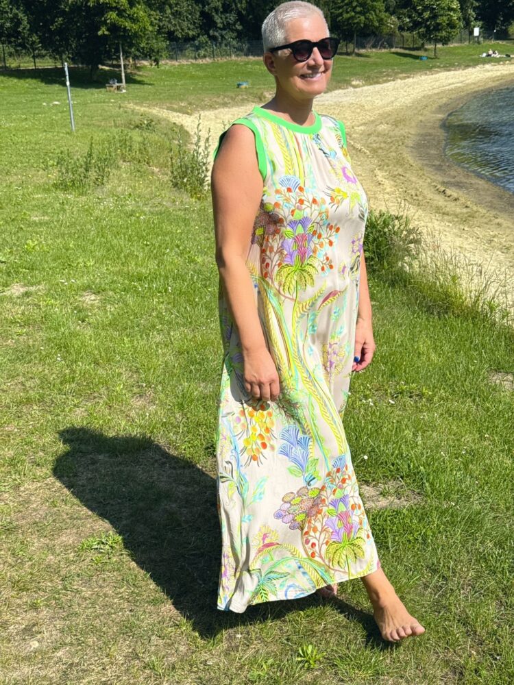 Frau mit Sonnenbrille am Seeufer.