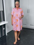 Frau im gestreiften Kleid mit Palmenmuster
