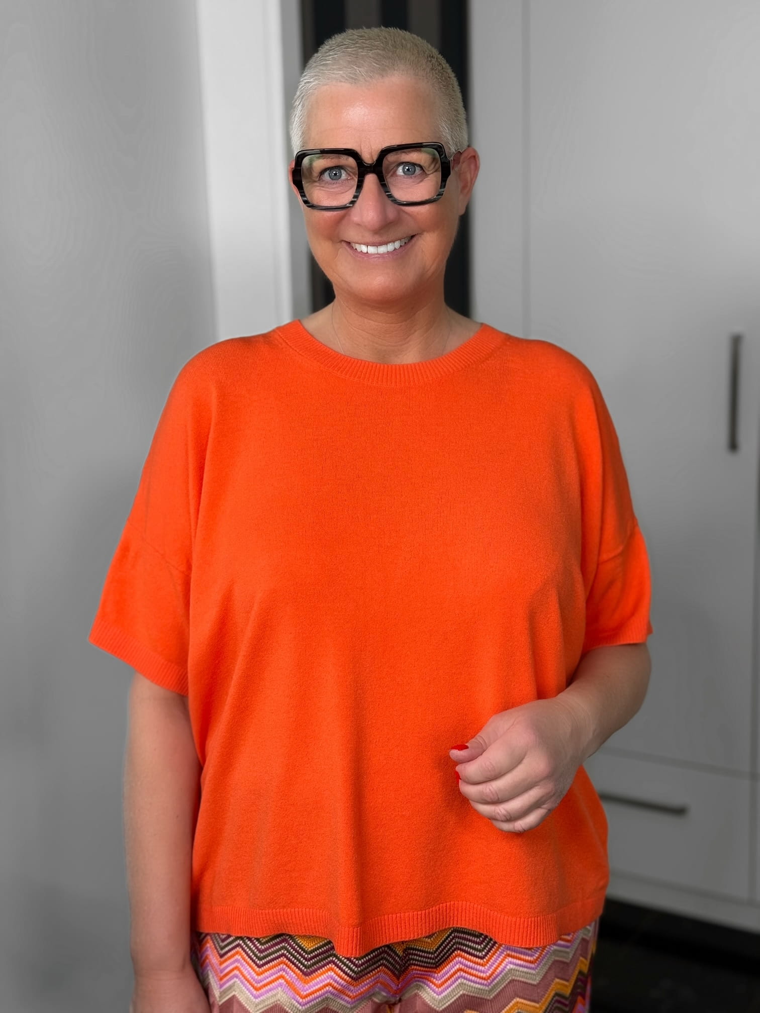 Milano Italy-Pulli-62-5268-9046-300-1 Lächelnde Frau mit Kurzhaarschnitt und orangem Pullover
