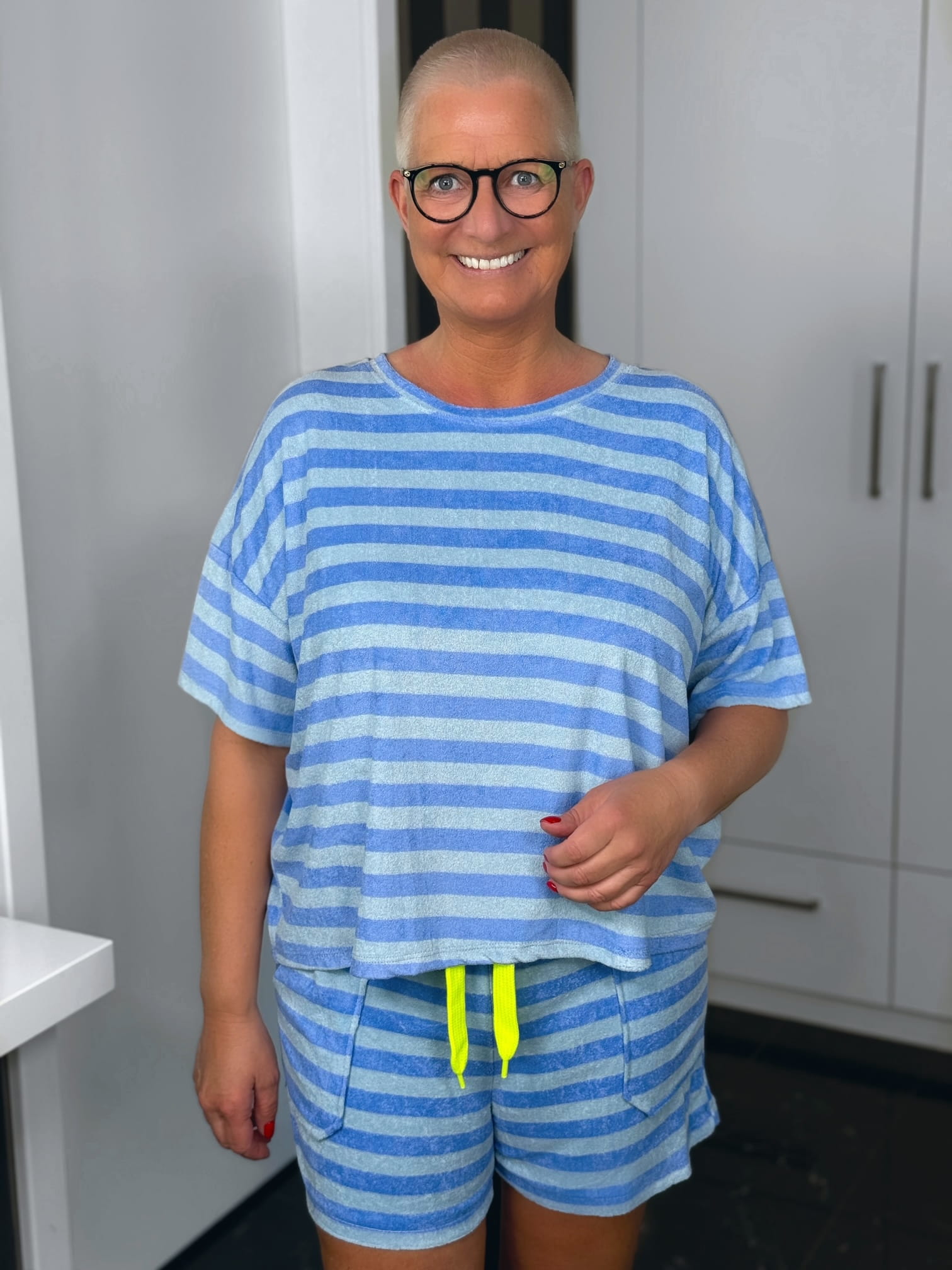 markenfest-Frottee-Set-H1393-hellblau-1 Lächelnde Frau mit Brille im blau gestreiften Outfit