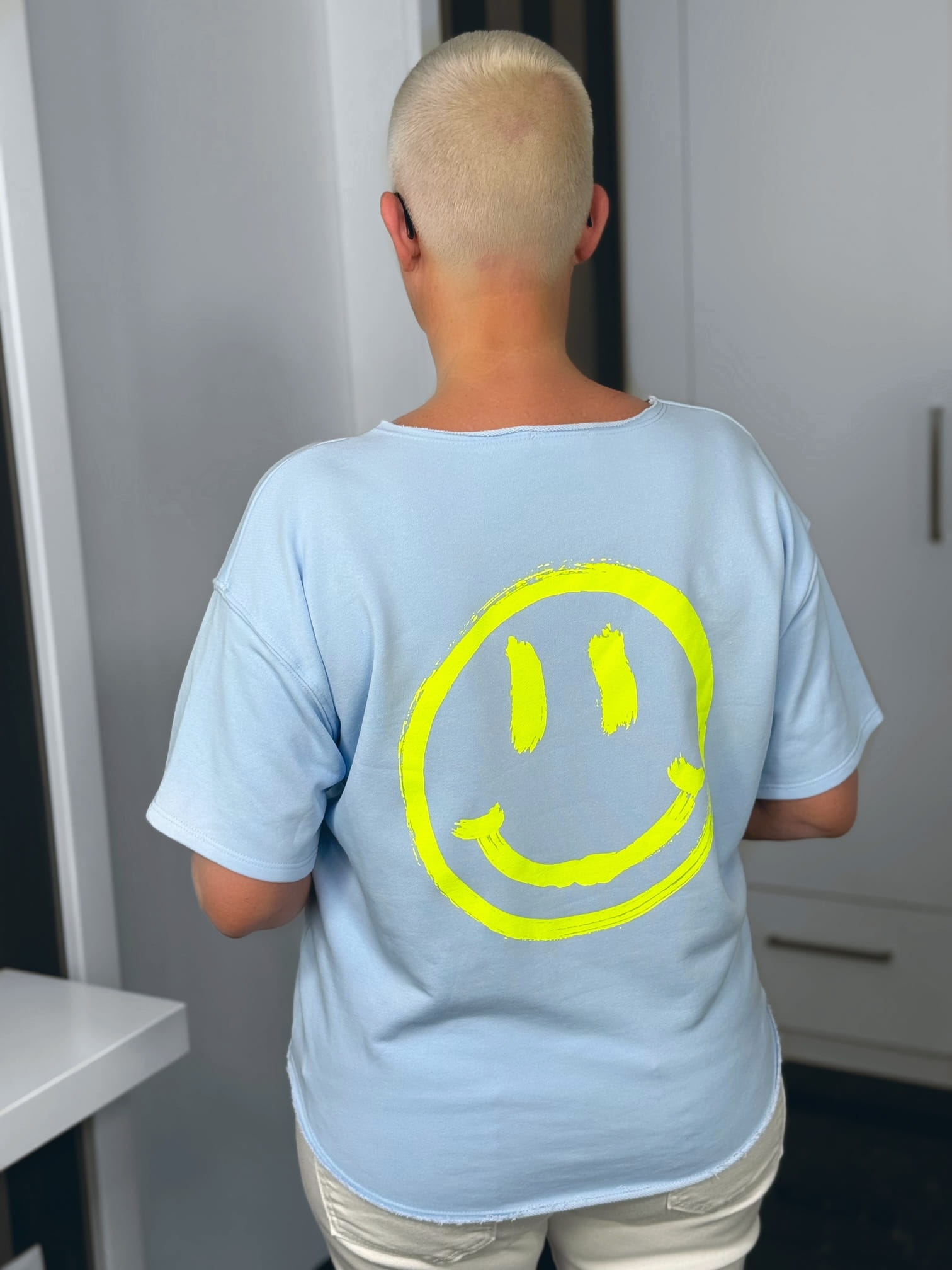 markenfest-Shirt-H1140-blau-6 Person mit Smiley-Shirt von hinten
