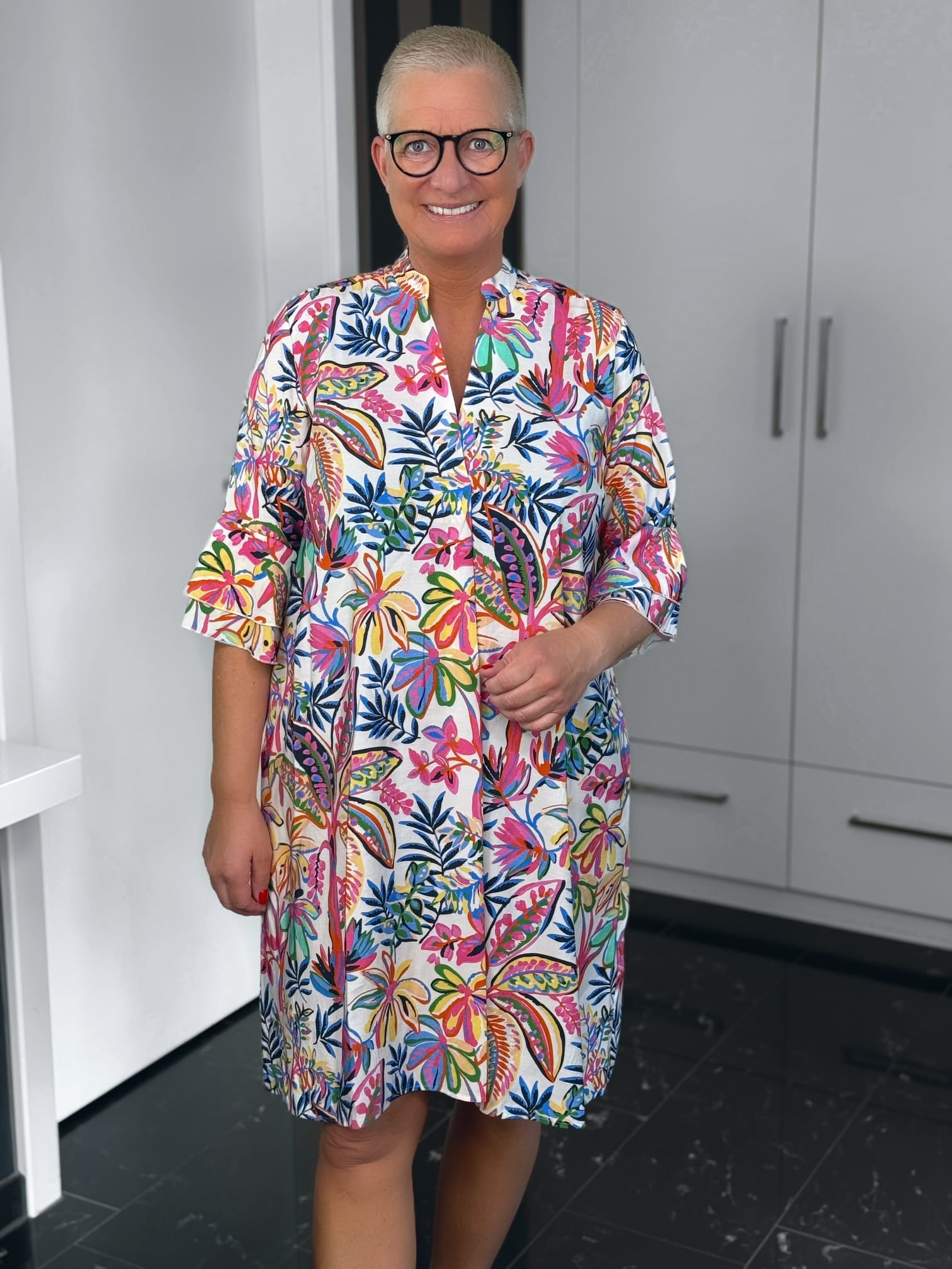 Milano Italy-Kleid-66-6525-1464-1300-3 Lächelnde Frau im bunten Blumenkleid mit Brille