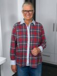 Lächelnde Frau mit Brille und kariertem Hemd