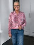 Lächelnde Frau mit Brille und gemusterter Bluse