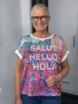 Lächelnde Frau mit Brille und buntem Shirt