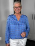 Lächelnde Frau mit Brille und blauer Bluse