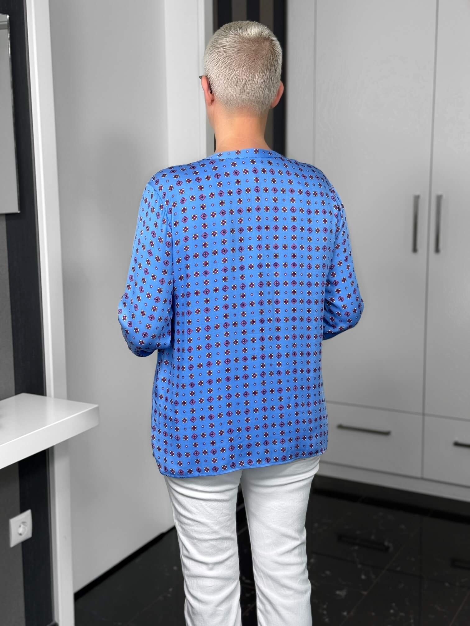 Milano Italy-Bluse-63-6574-3061-1600-8 Person mit blauer gemusterter Bluse von hinten