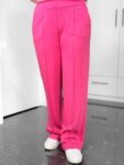 Pinkfarbene weite Stoffhose mit weißen Sneakern