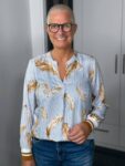 Lächelnde Frau mit Kurzhaarschnitt und Brille