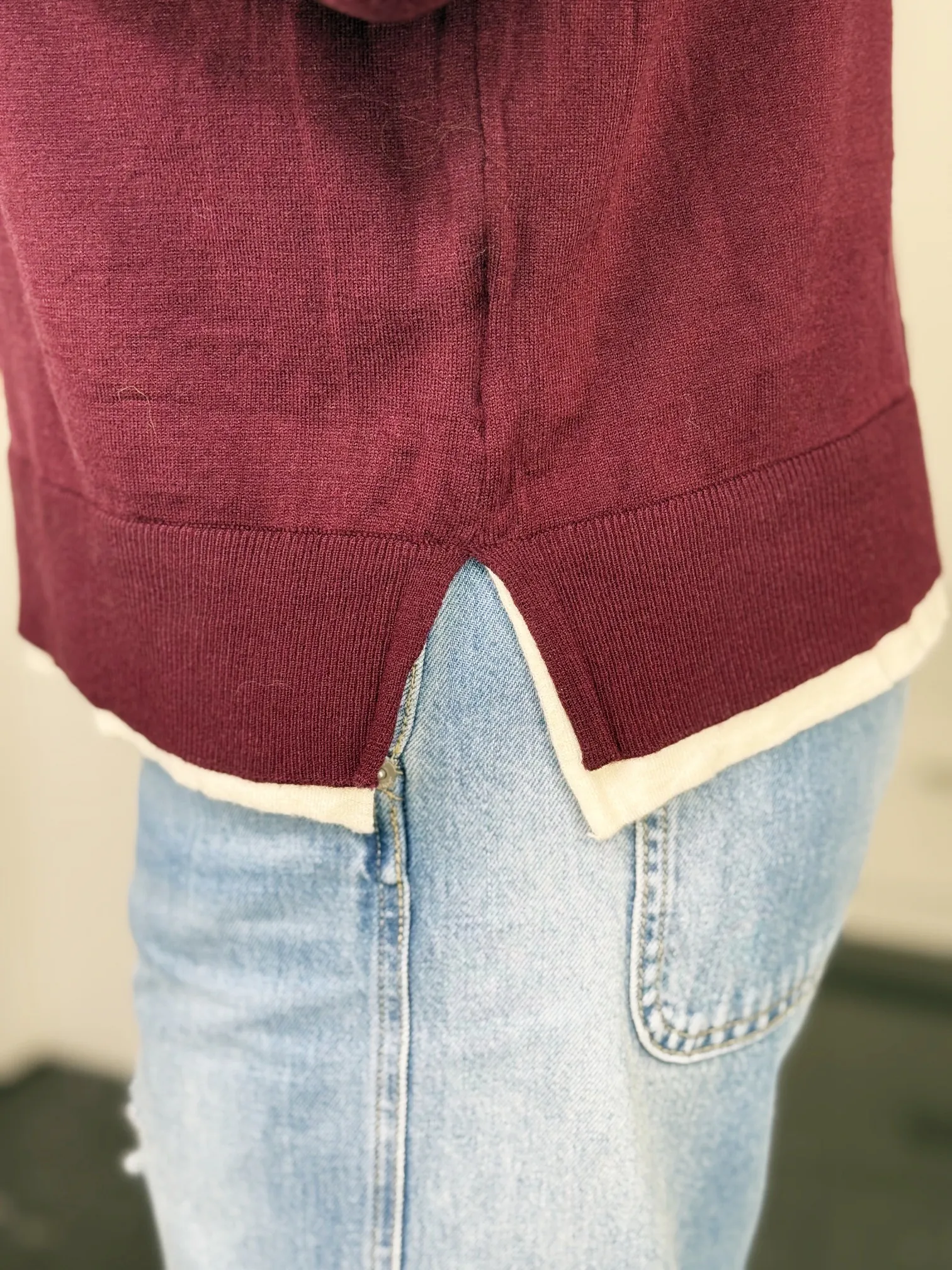 Feinstrickpullover Bordeaux Chic burgunder-creme – Detail Seitenschlitz Feinstrickpullover Bordeaux Chic in burgunder-creme – Detail Seitenschlitz